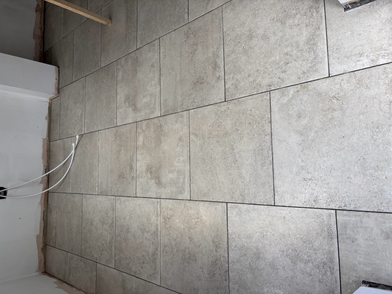 Grey rectangular floor tiles laid in an offset pattern