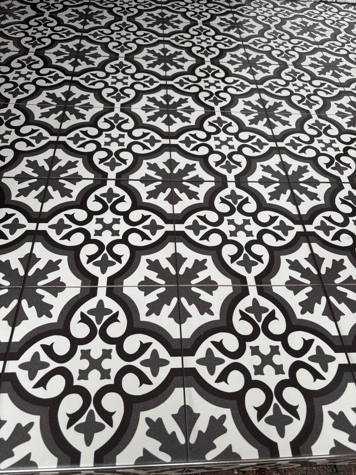 Black and white patterned entrance floor with carefully aligned grout lines