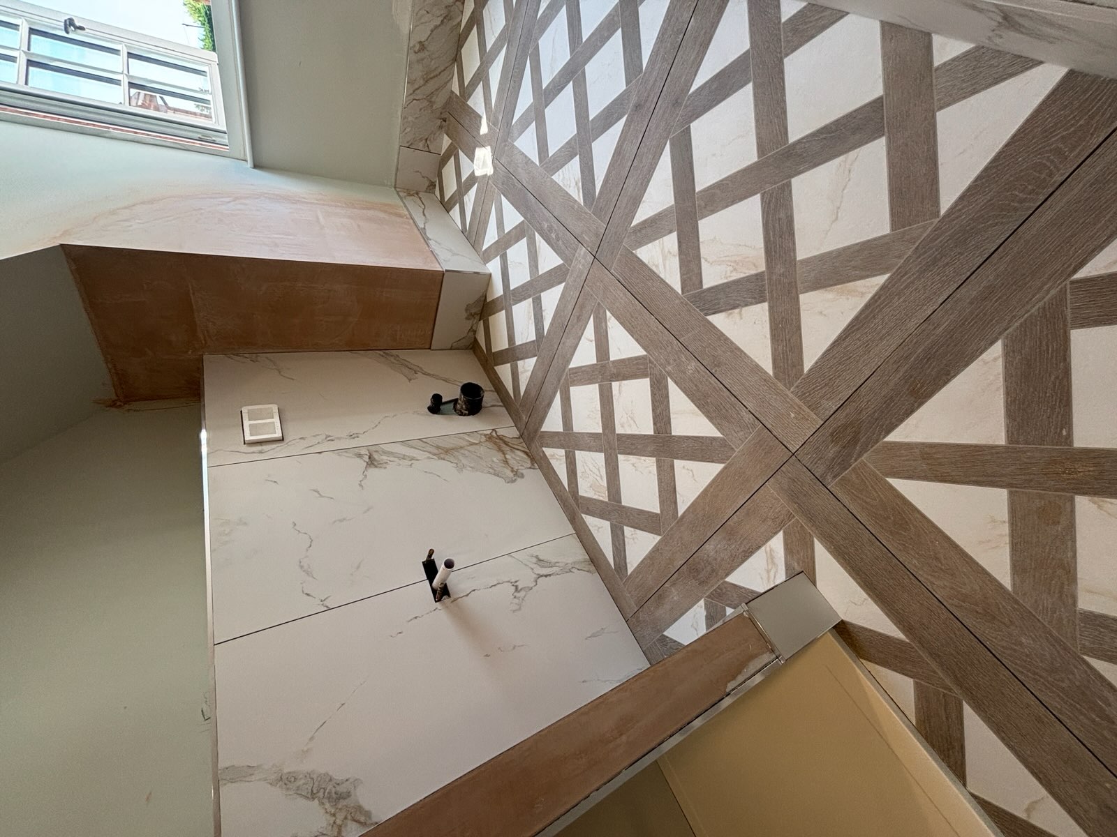 Detailed geometric bathroom floor tiles with marble-effect wall tiles
