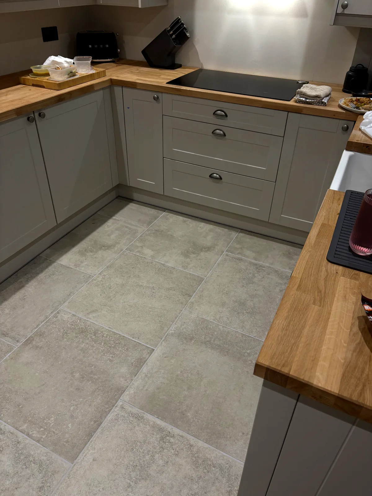 Close view of stone-effect kitchen floor tiles fitted neatly around the units