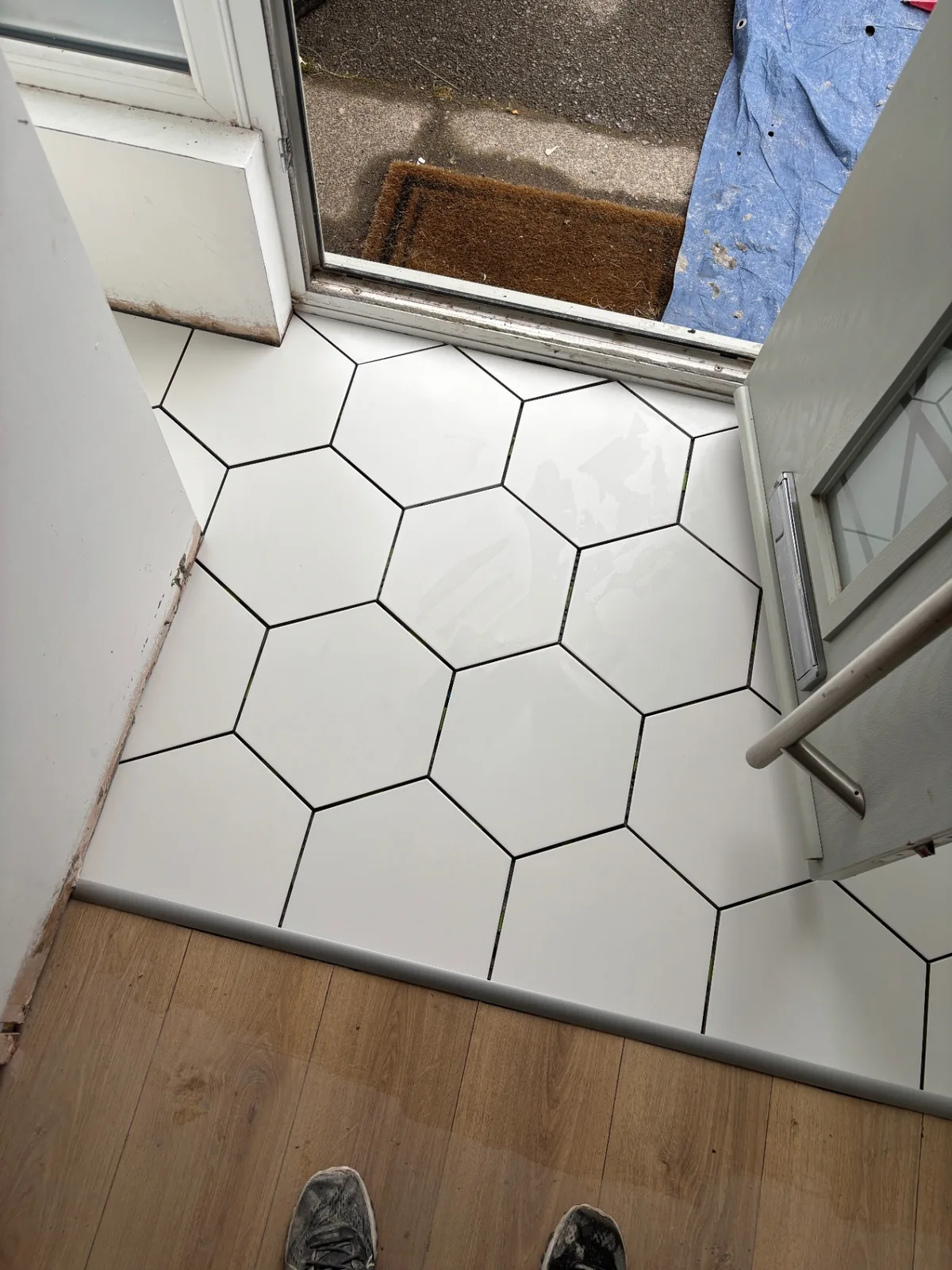White hexagonal floor tiles fitted neatly inside a compact entrance