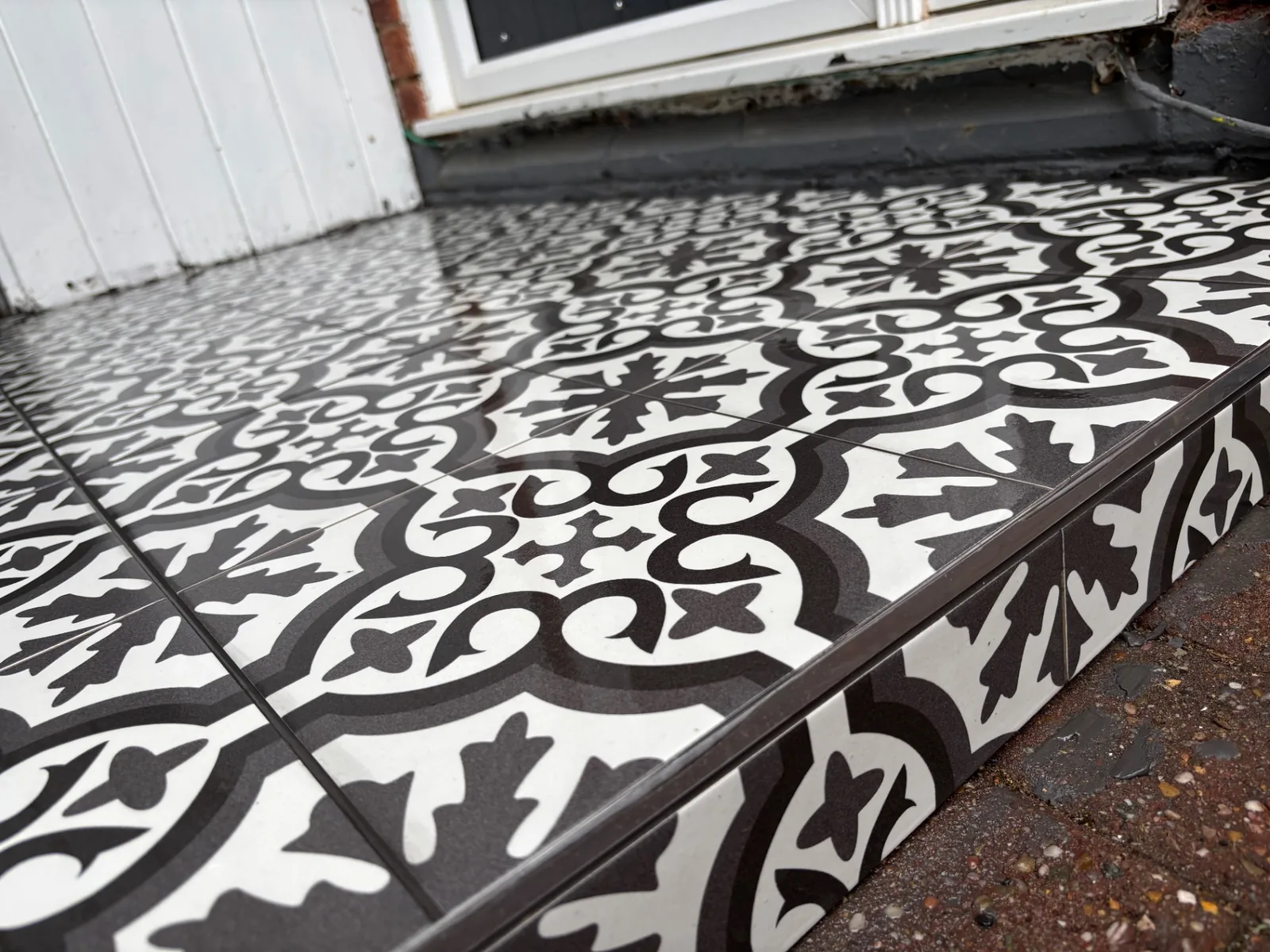 Close view of patterned entrance tiles finished neatly around the doorstep